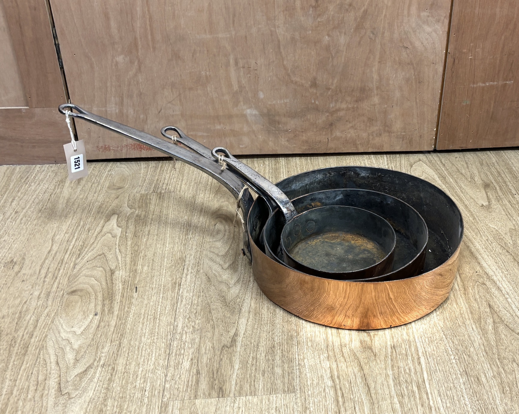 Three copper pans, largest diameter 35cm
